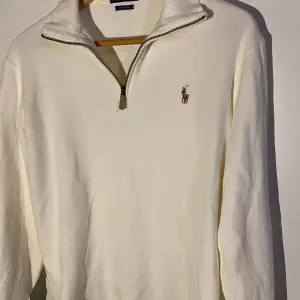 Säljer en stilren vit tröja från Polo Ralph Lauren. Den har en halv dragkedja och det klassiska broderade logotypen på bröstet. Perfekt för både vardag och lite finare tillfällen. Tröjan är i ny skick och passar perfekt till höst och vår. Ny pris på tröja är 2195.