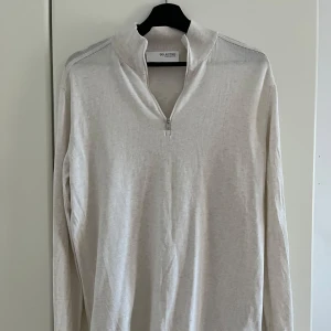 Vit långärmad tröja från Selected Homme - Säljer en stilren vit långärmad tröja från Selected Homme. Tröjan har en dragkedja vid halsen och är tillverkad i ett mjukt material. Perfekt för en avslappnad och snygg look.