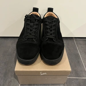 Christian Louboutin  - Säljer ett par snygga svarta sneakers från Christian Louboutin i mocka. De är i nytt skick och kommer med originalförpackning och tillbehör. Perfekta för både vardag och fest med sin stilrena design och bekväma passform. Passa på att köpa dessa lyxiga skor! Dock är det ett litet hål som är fixat men annars är skorna i utmärkt skick! Med mera frågor och bilder så är det bara att skriva🤝🙌