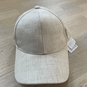 Beige keps från Gina Tricot - Helt oanvänd 
