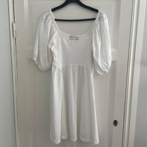 Vit klänning med puffärmar - Säljer en superfin vit klänning med puffärmar och broderade blommor. Den har en söt, luftig passform och är perfekt för sommardagar. 🌼 Köpt som eventuell studentklänning, men passar till alla möjliga tillfällen! Helt oanvänd. Nypris: 399kr.