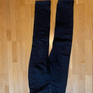 Svarta byxor från Trash Couture - Säljer ett par svarta byxor från Trash Couture. De har en snygg och stilren design med dragkedja och knapp framtill. Perfekta för både vardag och fest. Byxorna är i bra skick och passar till många olika outfits.