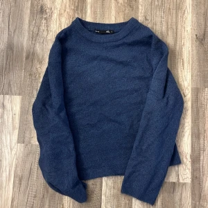 Mörkblå stickad tröja - Säljer en mysig mörkblå stickad tröja med långa ärmar. Perfekt för kyliga dagar och enkel att matcha med olika outfits. Tröjan har en klassisk design med rund halsringning. 