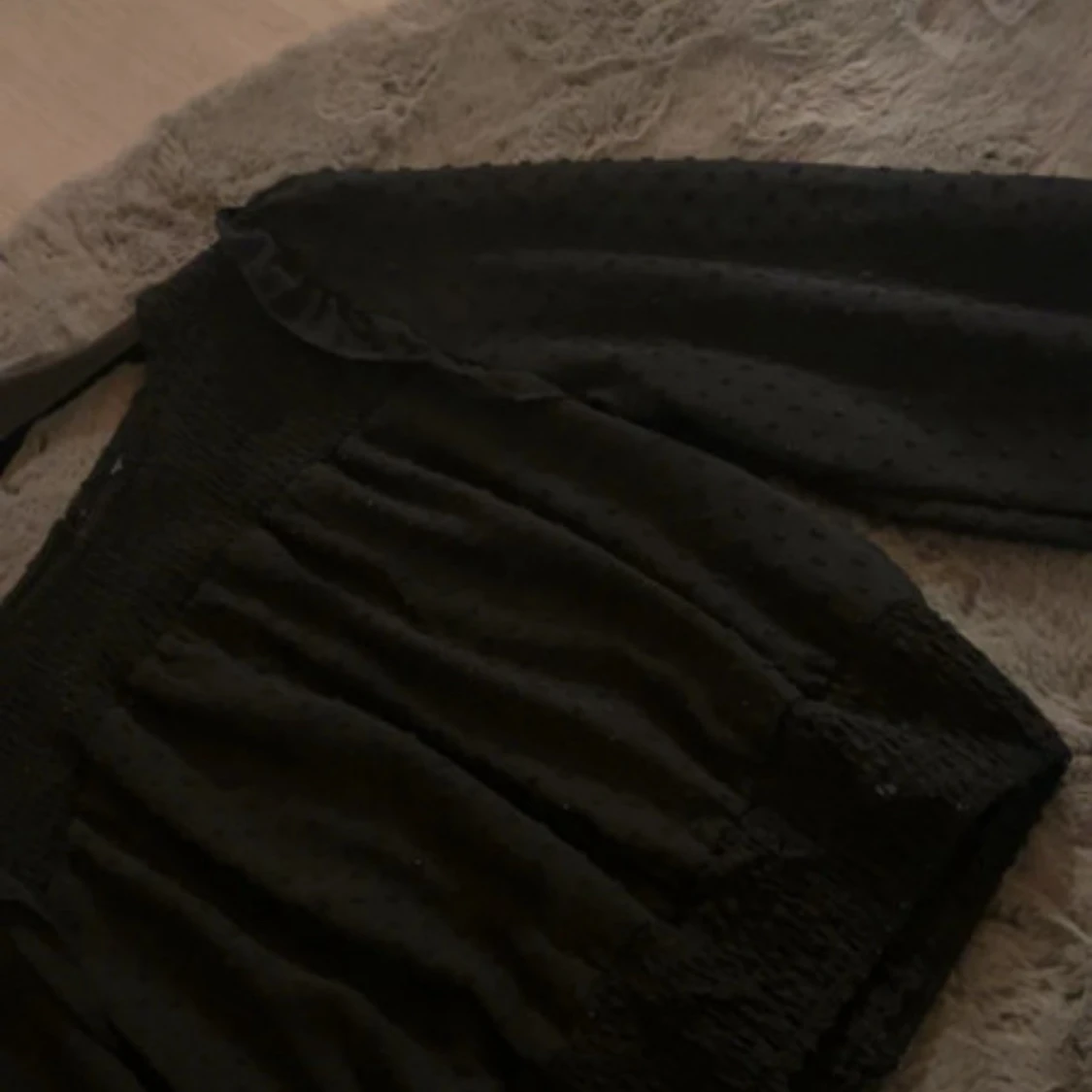 Svart blus med volangdetaljer