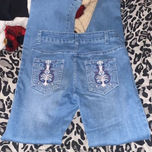 Broderade jeans från Shein - Säljer ett par ljusblå jeans från Shein i storlek XS. De har snygga broderade detaljer på bakfickorna, jeansen är ungefär Low Waist och bootcut. Använda ca 3 ggr❤️säljer pga kommer inte till användning ❤️skriv privat för mer bilder eller information ❤️