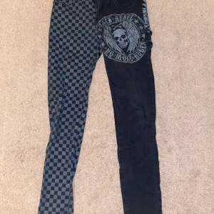 Rock Rebel asymmetriska jeans - Svarta rock rebel jeans med två olika ben och dödskalle.
