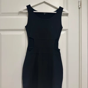 Svart klänning från Luclie - Elegant svart klänning från Luclie i storlek XS. Denna ärmlösa klänning har en stilren design med en figurnära passform och rund halsringning. Perfekt för en kväll ute eller en speciell tillställning.