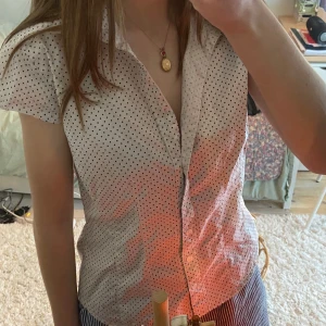 Vit prickig blus - Säljer en söt vit blus med små svarta prickar. Perfekt för både vardag och fest! Passar bra till jeans eller kjol💞