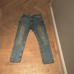 Blå jeans från Jack & Jones - Säljer ett par klassiska blå jeans från Jack & Jones i storlek 28/30. De har en straight passform och är i bra skick. Använda men inga skador. 