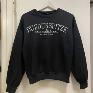 Svart sweatshirt med tryck, är nopprig där av priset 