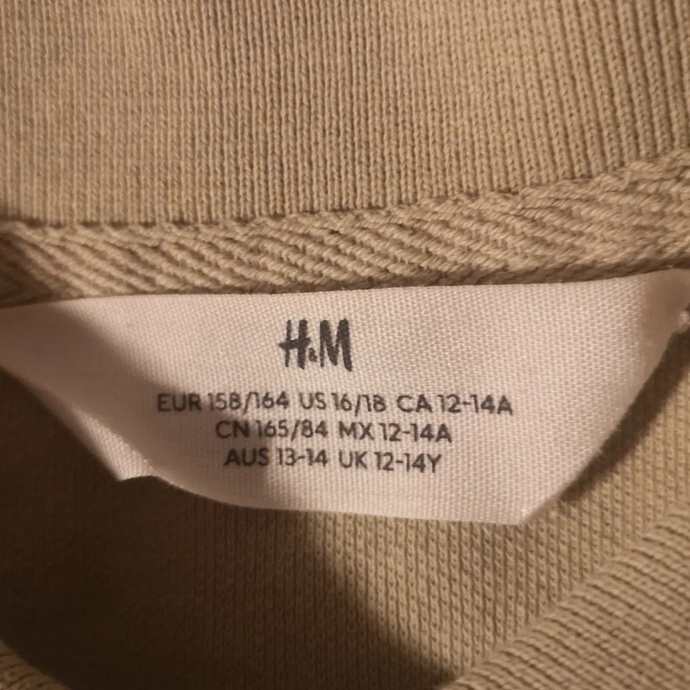Säljer en klassisk beige pikétröja från H&M i storlek EUR 158/164. Perfekt för en avslappnad stil, med korta ärmar och knappar framtill. Tröjan är i bra skick och passar både till vardags och lite finare tillfällen. Skön och enkel att matcha med det mesta! 🌟. T-paidat.