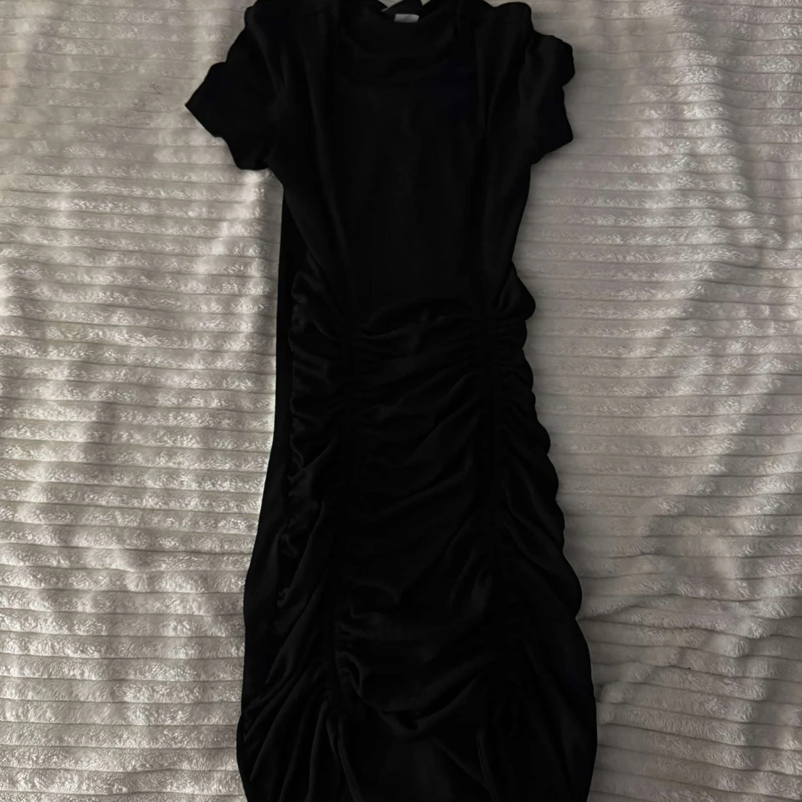 Svart klänning med rynkdetaljer