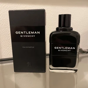 Gentleman Givenchy Eau de Parfum - Säljer en elegant och maskulin parfym från Givenchy. Flaskan är stilren och svart med en modern design. Perfekt för den sofistikerade mannen som vill ha en doft som håller hela dagen. Kommer i originalförpackning.