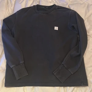 Svart tröja från Neuw - Säljer en stilren svart tröja från Neuw. Tröjan har långa ärmar och en enkel design med en liten logotyp på bröstet. Perfekt för en avslappnad look. Den är strl M men är loose i formen så passar större också. 