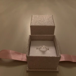 Silverring med klar sten - Elegant silverring med en klar sten i mitten. Ringen är i sterling silver, vilket framgår av stämpeln 925 på insidan. Perfekt för speciella tillfällen eller som en fin present. Aldrig använd!
