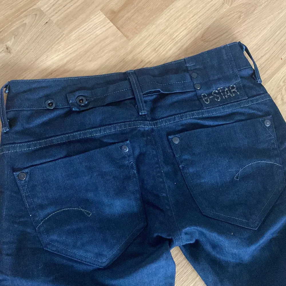 Ett par snygga lågmidjade g-star jeans i bra skick. Skulle säga att de är bootcut. Midjemåttet är ca 39 cm rakt över. Innerbenslängden är 78 cm. Färgen är mörkblå/svart. Jeans & Byxor.