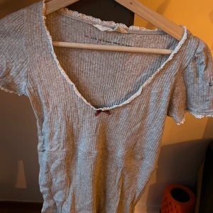 Grå topp från Odd Molly - Säljer en superfin grå topp/blus från Odd Molly i storlek 1. Den har korta ärmar  spetsdetaljer. Lite skrynklig på bilderna. 