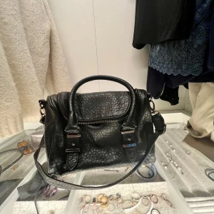 Svart Zadig liknande axelväska i skinn - Säljer en snygg svart axelväska i skinn! Väskan har både handtag och en justerbar axelrem. Väskan är köpt secondhand och om du har några fler frågor är det bara att kontakta mig 🌸
