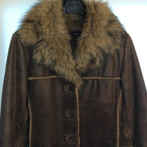 Äkta skinnjacka med fuskpäls - Äkta skinnjacka i nyskick, knappt använd, äkta läder och fuskpäls, ren och fräsch. Två fickor i sidan och en på insidan. Mycket fin och varm. 