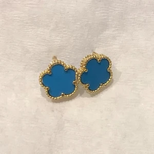 Clover örhängen kornblå & guld  - Aldrig använd dessa Perfekt skick :) mild blå färg Riktigt fina lite ljusare än bilderna vet ej varför de blir lite mörka på foto. Passar  till andra guldiga smycken och klänning eller vardags jeans 👸🏻☀️klöver smycken 🍀som cleef style 