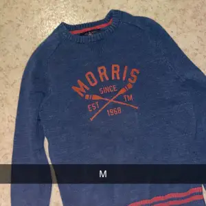 Säljer en snygg blå tröja från Morris med orange text och detaljer. Perfekt för en casual look. Tröjan har långa ärmar och är i mycket bra skick. Passar perfekt till höst och vår!