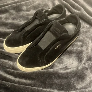 Svarta sneakers från Axel Arigato - Säljer ett par stilrena svarta sneakers från Axel Arigato. De är i nyskick och har en snygg, minimalistisk design med en vit sula. Perfekta för både vardag och fest! 🖤