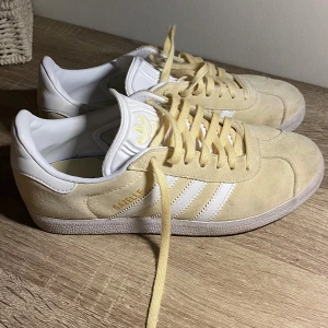 Ljusgula Adidas Gazelle - Superfina skor i en jättefin gul färg!💛💛Köpta på arkivet men knappt använda, så i mycket gott skick. De är även jättesköna!! Säljer även matchande halsduk och väska (kolla min profil) Säljer pga dem är för små💕