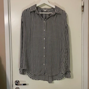 Skjorta - Säljer en  svartvit rutig skjorta. Skjortan är i nyskick och passar bra till höst och vår. Storleken är M.
