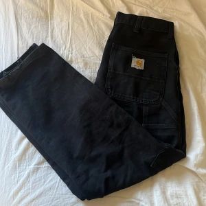 Carhartt jeans  - Säljer ett par snygga carhartt byxor, dom är i fint skick förutom att de är lite slitna där nere som jag tog bild på,ny pris ligger på runt  1 200 kr.  kan gå ned i pris vid snabb affär, mvh