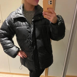 C.W dunjacka svart  - En snygg jacka i en svart färg från Carin Wester. Jackan har en hög krage och en dragkedja framtill. Den har även två fickor på sidorna. Jackan är i gott skick.. I storlek XS men är oversized! Sparsamt använd. Inga defekter! Supersnygg och bekväm!