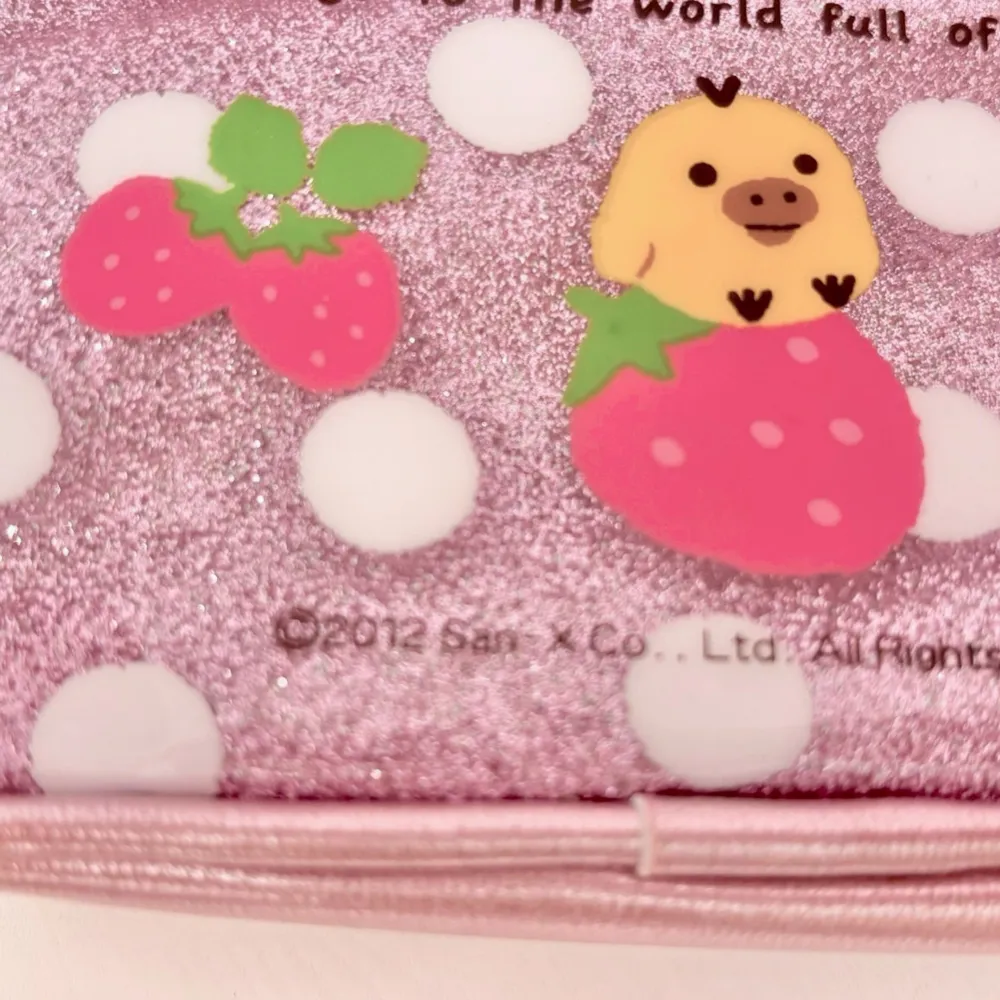 Ett söt och kompakt pennfodral med Rilakkuma-motiv. Den har en glittrande design med vita prickar och en söt liten måne-charm. Perfekt för att förvara Pennor, småpengar, kort eller andra småsaker.  Köpt från Japan Release: 2012. Accessoarer.