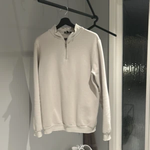 Beige tröja från boohooMAN - Säljer en stilren beige tröja från boohooMAN i storlek S. Tröjan har en dragkedja vid halsen och är perfekt för både vardag och avslappnade tillfällen. Den är långärmad och gjord i ett mjukt material som känns skönt mot huden. Passar perfekt till höst och vår!