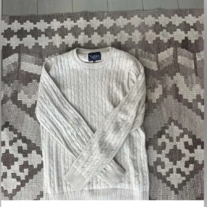Vit stickad tröja från bondelid  - Säljer en stilren vit stickad tröja från bondelid . Den har ett klassiskt flätmönster och är perfekt för kyliga dagar. Tröjan är långärmad med ribbade muddar och rund hals. Passar både till vardags och lite finare tillfällen. Jätte bra skick.