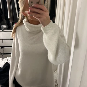 Vit polotröja från VILA - Mysig vit polotröja från VILA i mycket bra skick. Perfekt för kyliga dagar med sin mjuka och varma känsla. Tröjan har en klassisk polokrage och långa ärmar, vilket gör den idealisk för både vardag och mer uppklädda tillfällen. Ett måste i garderoben för höst och vinter!