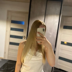 Vit satinlinne - Säljer ett stilrent vitt linne i satinmaterial. Perfekt för sommardagar eller en kväll ute. Linnet har smala axelband och en enkel design som gör det lätt att matcha med olika outfits. Det är i nyskick och redo för en ny ägare!