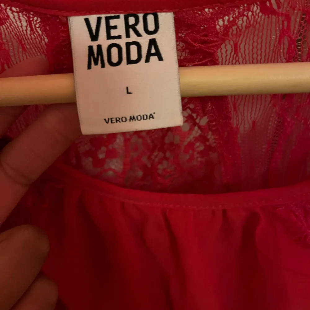 Snygg rosa blus från Vero Moda i storlek L. Den är ärmlös med spetsdetaljer upptill och en luftig passform. Perfekt för sommarens fester eller en dag på stan. Klänningen har en vacker öppen rygg och är gjord i ett lätt och bekvämt material.. Blusar.