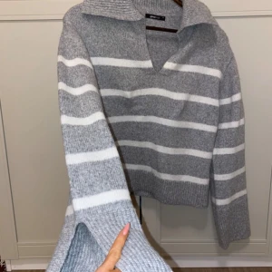 Grå och vit randig tröja från Zara - Säljer en superfin grå och vit randig tröja från Gina . Den är i mycket bra skick och har en snygg v-ringad krage. I ny skick. Storlek XS men då den e Oversize passar den XS-M