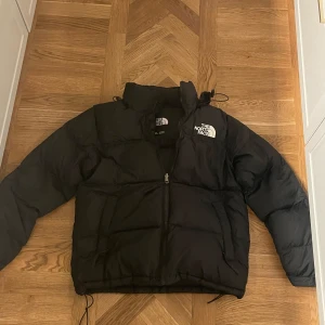 North Face Puffer Jack - Säljer en svart dunjacka från The North Face i mycket bra skick. Jackan har en dragkedja framtill och är perfekt för kalla vinterdagar. Den är långärmad och har en normal passform. Loggan syns tydligt både fram och bak.⚡️🔥🔥🔥🔥