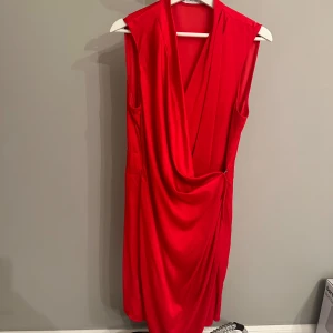 Röd omlottklänning från Mango silk - Snygg röd omlottklänning från Mango i storlek XL. Perfekt för festliga tillfällen med sin eleganta drapering och ärmlösa design. Klänningen har en smickrande passform och är tillverkad i ett mjukt, bekvämt material. 