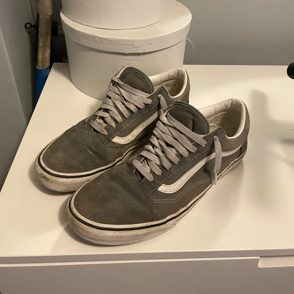 Säljer ett par grå Vans sneakers i bra skick. De har en klassisk design med vit sula och snörning. Perfekta för vardagsbruk och ger en skön streetstyle-look. Lite slitna men fortfarande snygga och bekväma.. Skor.