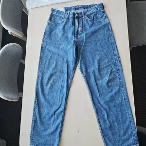 Blå loose fit jeans från H&M - Säljer ett par snygga blå loose fit jeans från H&M i storlek M. De har en klassisk femficksdesign och är perfekta för en avslappnad stil. Jeansen är i mycket bra skick och passar perfekt för både vardag och chill.