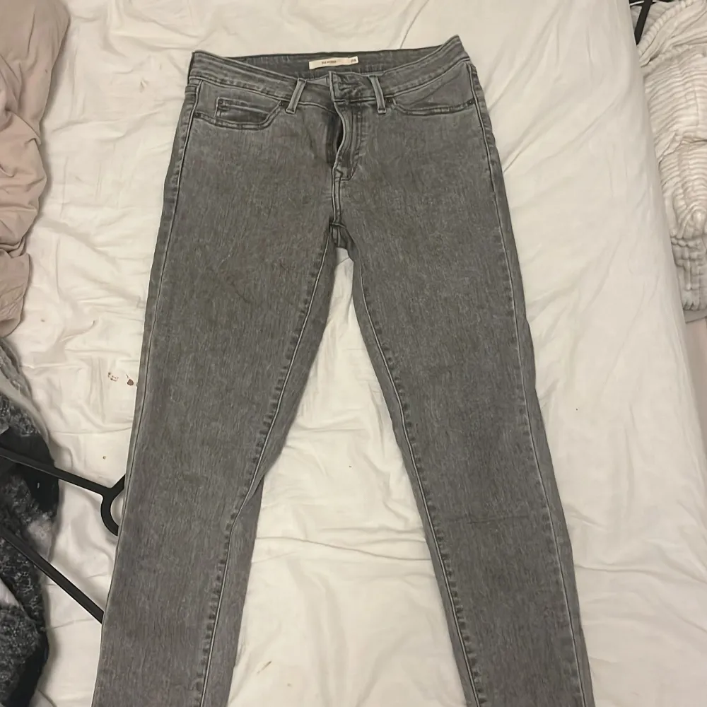 Säljer ett par grå Levis 711 Skinny jeans i bra skick. De är tighta och har en klassisk femficksdesign med dragkedja och knapp. Perfekta för både vardag och fest! 🖤. Jeans & Byxor.