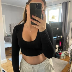 Svart topp - Svart kort topp med urringning 