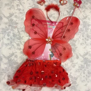 Röd fjärilskostym för barn - Superfin röd fjärilskostym för barn med glittriga vingar och en matchande kjol. Perfekt för lek och utklädnad! Setet inkluderar även ett diadem med antenner och en trollstav. Vingarna har stjärndetaljer och kjolen är dekorerad med paljetter för extra glans. 🦋✨ 125kr/paket, finns fler kvar, sammafrakt. 3år +