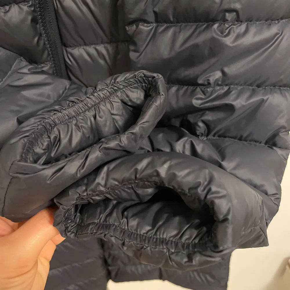 Säljer en snygg grå dunjacka från Moncler i mycket bra skick. Jackan har en quiltad design med dragkedja och knappar vid kragen. Perfekt för höst och vinter, håller dig varm och stilren. . Jackor.