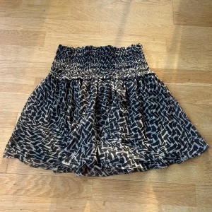 Mönstrad kjol H&M - Säljer en superfin mönstrad kjol från H&M i storlek 36. Kjolen har en elastisk midja som gör den bekväm och lätt att bära. Perfekt för både vardag och fest! Materialet är 100% polyester, vilket gör den lätt och luftig. Aldrig använd bara testad 🖤