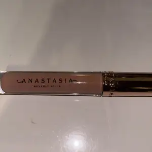 Snyggt läppglans från Anastasia Beverly Hills i en neutral beige nyans. Perfekt för en naturlig look med lite glans. Kommer i en elegant förpackning med guldig kork. Perfekt för både vardag och fest!