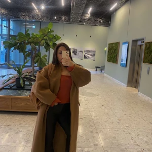 Brun kappa - Säljer en snygg brun kappa i lång modell. Den har en stilren design med långa ärmar och en slits baktill. Perfekt för höst och vår, och ger en elegant touch till vilken outfit som helst. Passar både till vardags och festliga tillfällen. Nypris: 2600kr