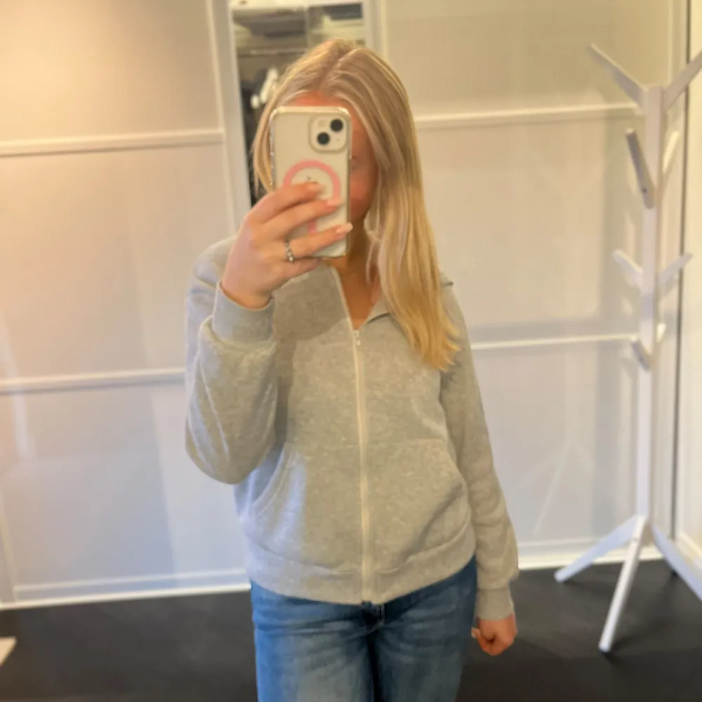 Mysig grå hoodie i bra skick med dragkedja framtill. Perfekt för höst och vår, med långa ärmar och ribbade muddar. Skön att ha på sig till vardags eller när du bara vill chilla. Passar perfekt till jeans eller leggings! Tags är bortklippta. Tröjor & Koftor.