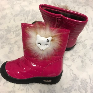 Rosa vinterstövlar med pälsdetalj - Säljer ett par supercoola rosa vinterstövlar med en fluffig pälsdetalj och en söt djurdesign framtill. De har en dragkedja på sidan för enkel på- och avtagning. Perfekta för att hålla fötterna varma och stiliga under kalla dagar!     Stlk kvar 27,29,30 31 .  Med fleece inuti, rekommenderar att välja en stlk större 
